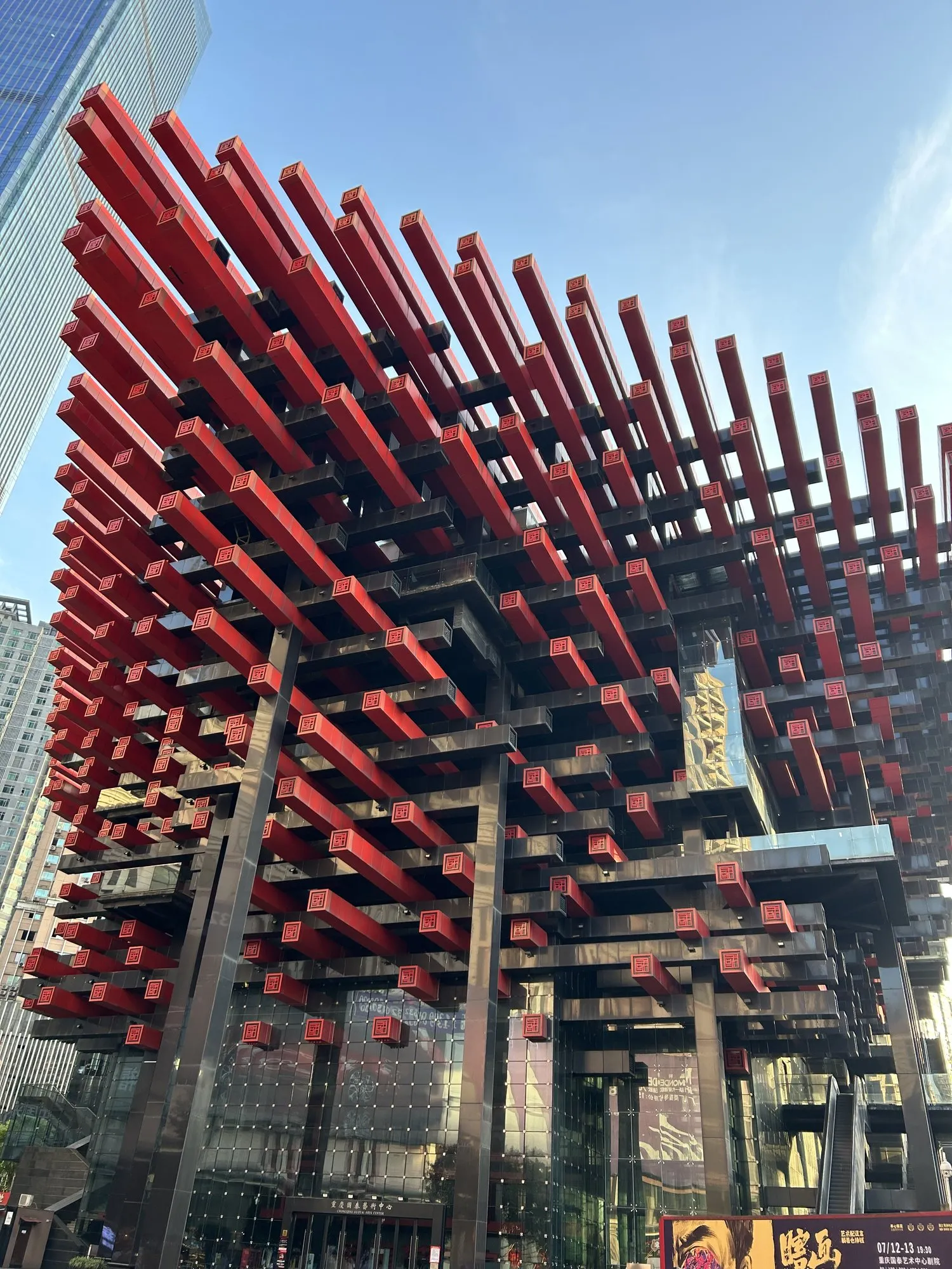 Looking up at a building wrapped in a dense red wooden lattice.